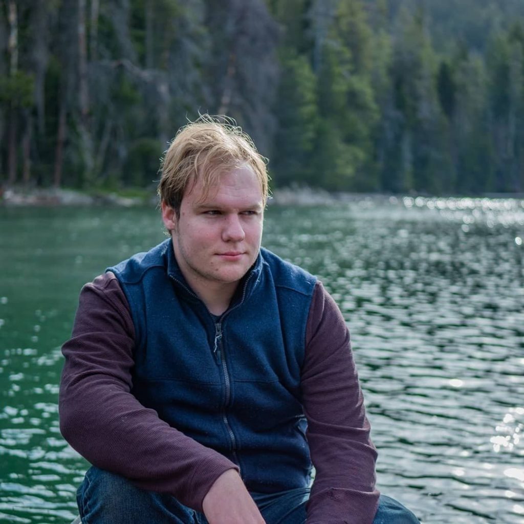 Nicholas sitting in a boat on a lake
